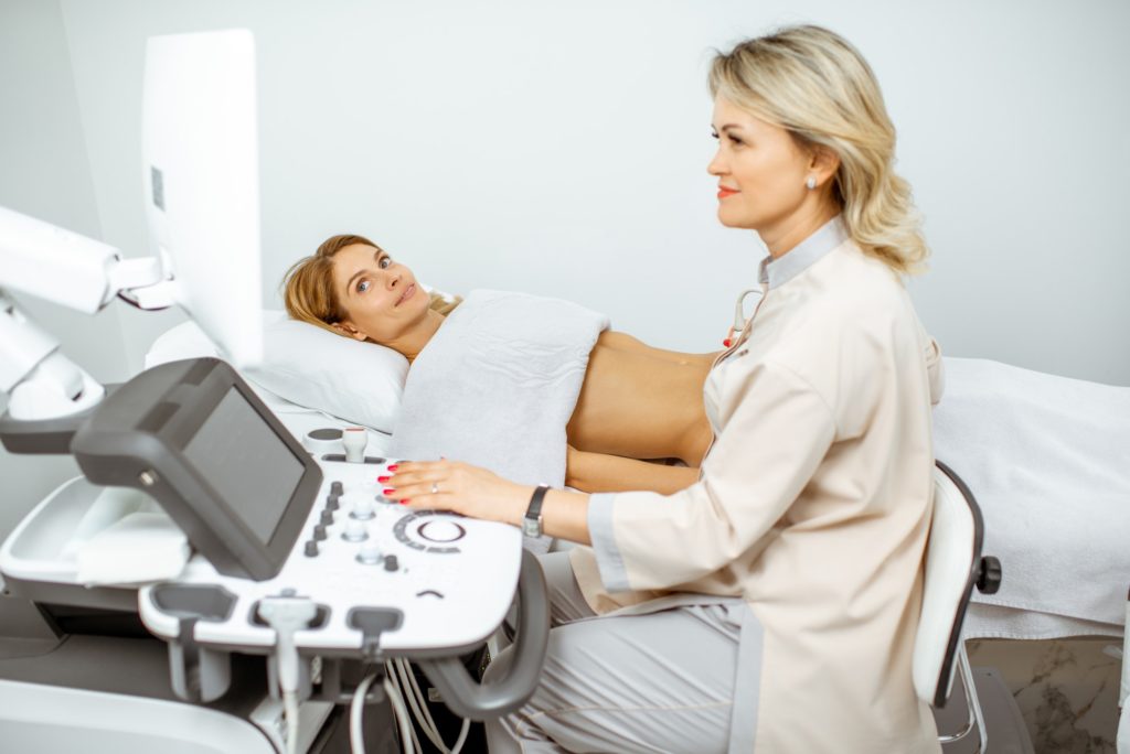 Doctor performs ultrasound examination of a woman