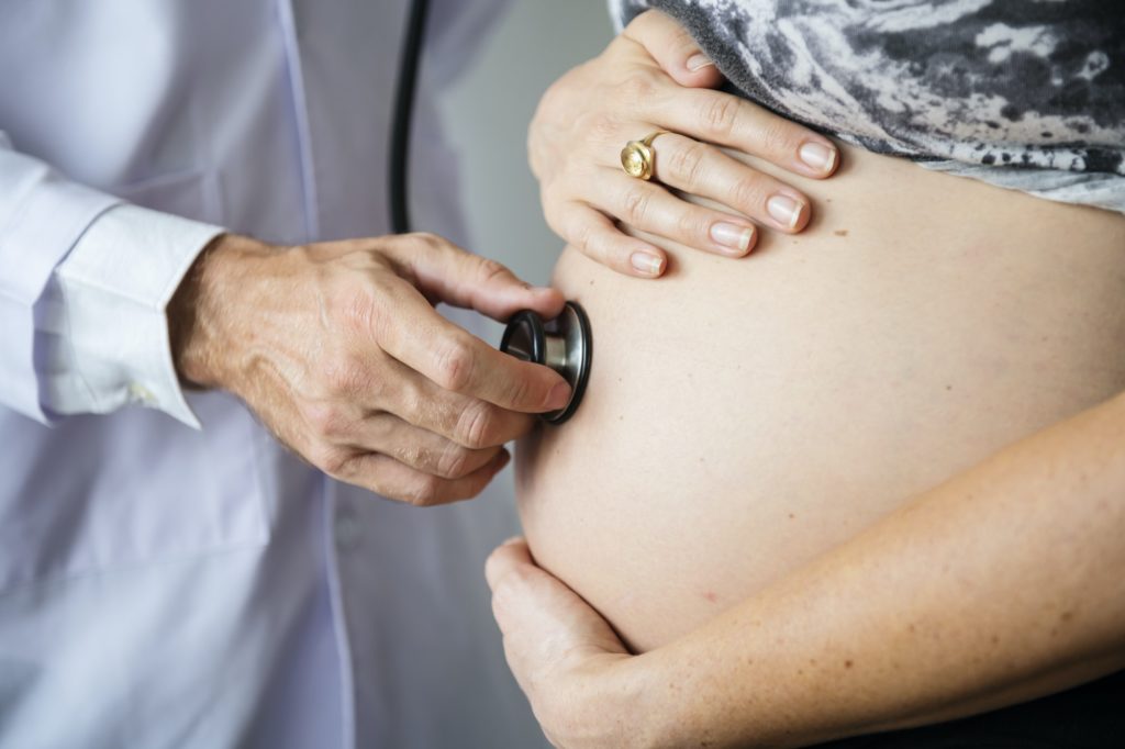 Pregnant woman having fetal monitoring by doctor