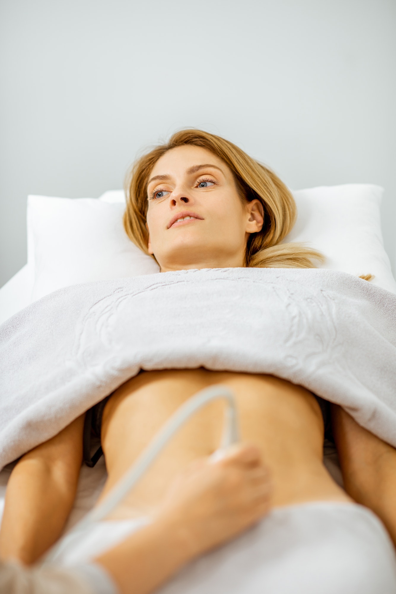 Woman examining her abdomen with ultrasound